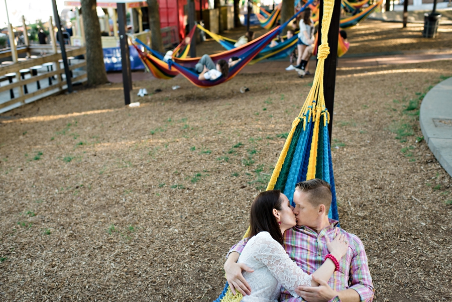 A cute couple kiss in a hammock in a beer garden in philadelphia.